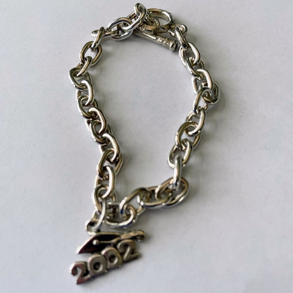 Silver charm bracelet with adjustable catch. Old charm you can detach.